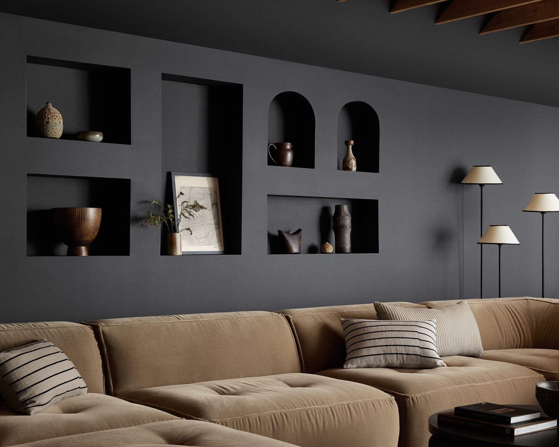 A black living room wall with niches