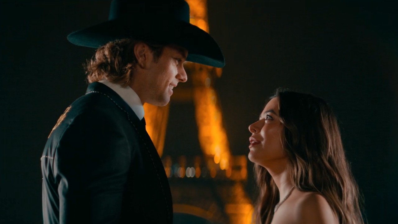 Trey and Dawn looking lovingly at each other while standing in front of a lit up Eiffel Tower.