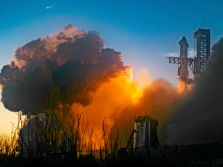 a giant rocket lifts from its launchpad, smoldering plumes of smoke erupt around
