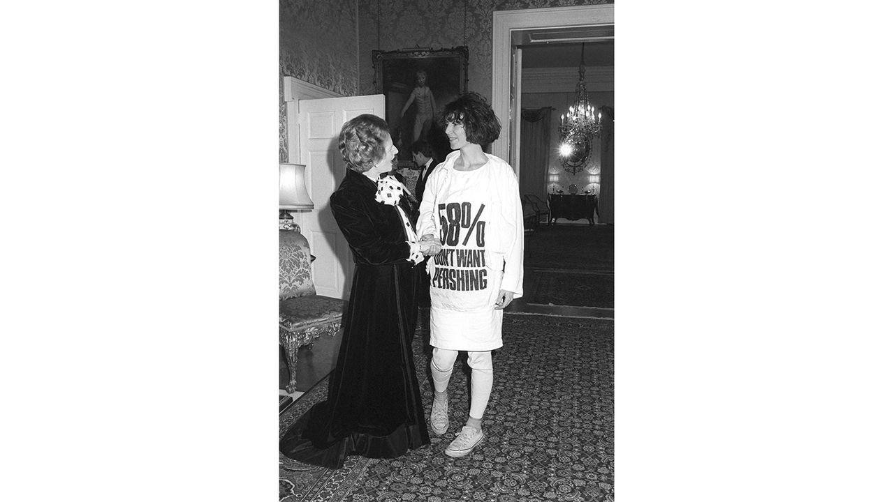 Prime Minister Margaret Thatcher greets fashion designer Katharine Hamnett, wearing a t-shirt with a nuclear missile protest message, at 10 Downing Street, where she hosted a reception for Br