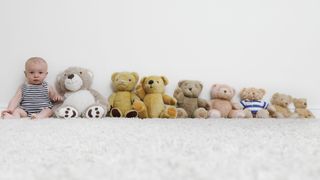 Baby sat with line of teddy bears