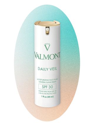 Valmont sunscreen on an ombre blue and peach background