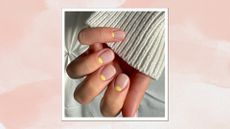 A close up of a hand with a lemon half-moon manicure by nail artist @gel.bymegn to demonstrate a stylish alternative to lemon French tip nails/ in a pink watercolour paint-style template