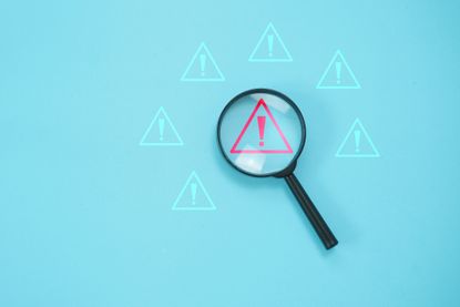 Magnifier focus on warning alert alarm concept, to finding the error and alert warning on system,