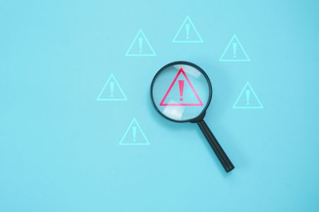 Magnifier focus on warning alert alarm concept, to finding the error and alert warning on system,