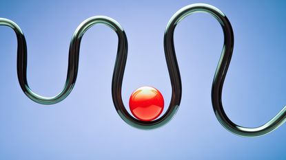 A red ball sits at a low point on top of a black tube that's curving up and down.
