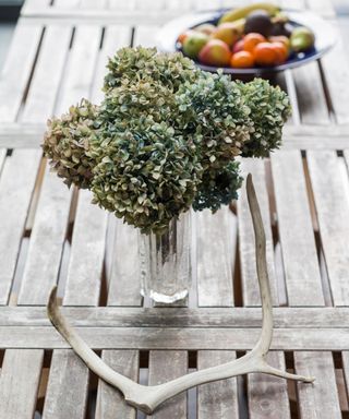 Dried flowers in a vase on a wooden table on the porch - alamy