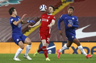 Liverpool forward Diogo Jota controls the ball on his chest as he is challenged by Chelsea's Reece James and Cesar Azpilicueta