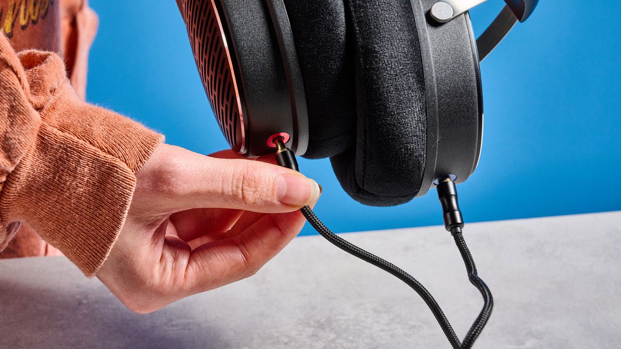 the FiiO JT3 headphones in black and silver shown against a blue tom's guide background