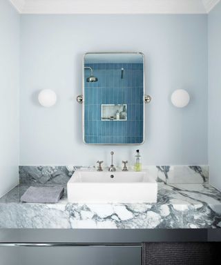 bathroom with marble sink and blue tiles