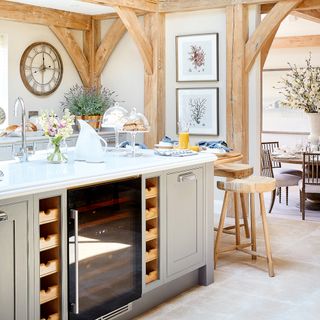 Kitchen with exposed oak beams, large kitchen island and breakfast bar with view through an arch to the dining room