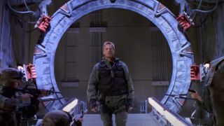 Richard Dean Anderson stands in front of the Stargate in Stargate SG-1