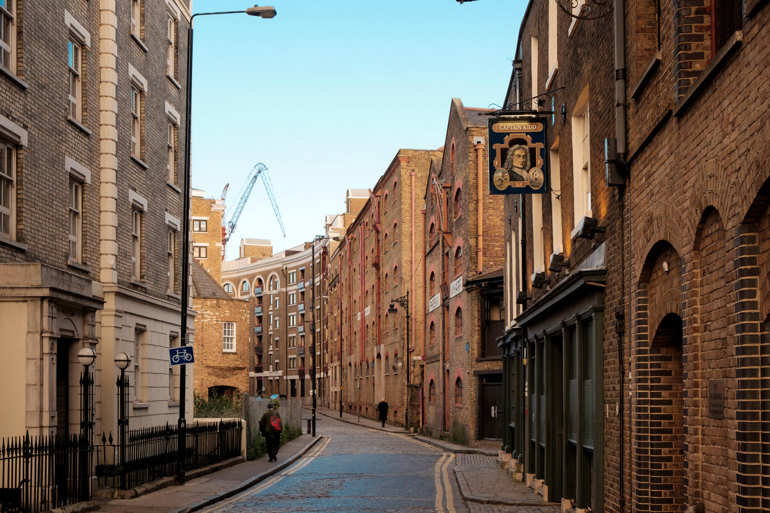A view of a street filled with warehouses and the sign for the Capt Kidd pub