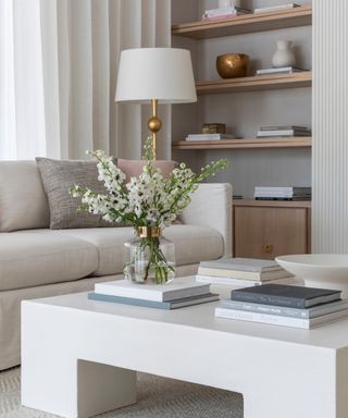 living room white white coffee table with vase of flowers and books