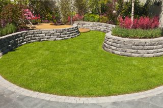 curved grey stone wall on lawn