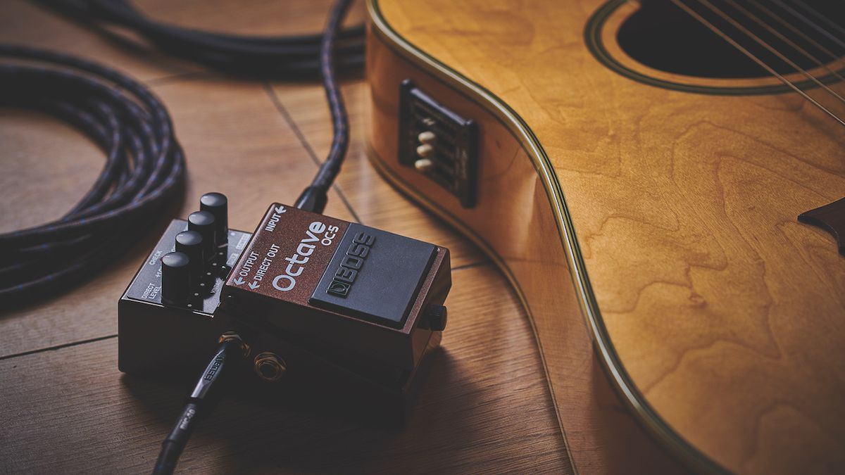 A Boss Octave OC-5 pedal, posed next to an acoustic guitar