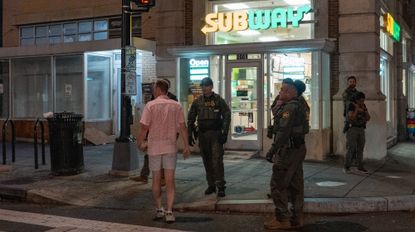 WASHINGTON, DC - AUGUST 10: A man, who was later arrested. for assaulting law enforcement with a sandwich, interacts with Border Patrol and FBI agents along the U Street corridor on August 10, 2025, in Washington, DC. U.S. President Donald Trump ordered an increased presence of federal law enforcement to Washington, DC in an effort to curb crime. 