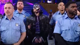 Dominik Mysterio being led to the ring by police officers at WrestleMania 39