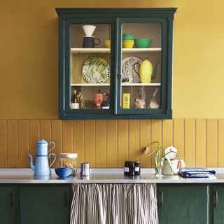 small glass wall cabinet in yellow and green kitchen