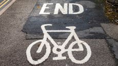 Image shows a painted bike lane with 'end' written on the road