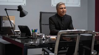 Nate sits at his desk wearing a suit in Ted Lasso