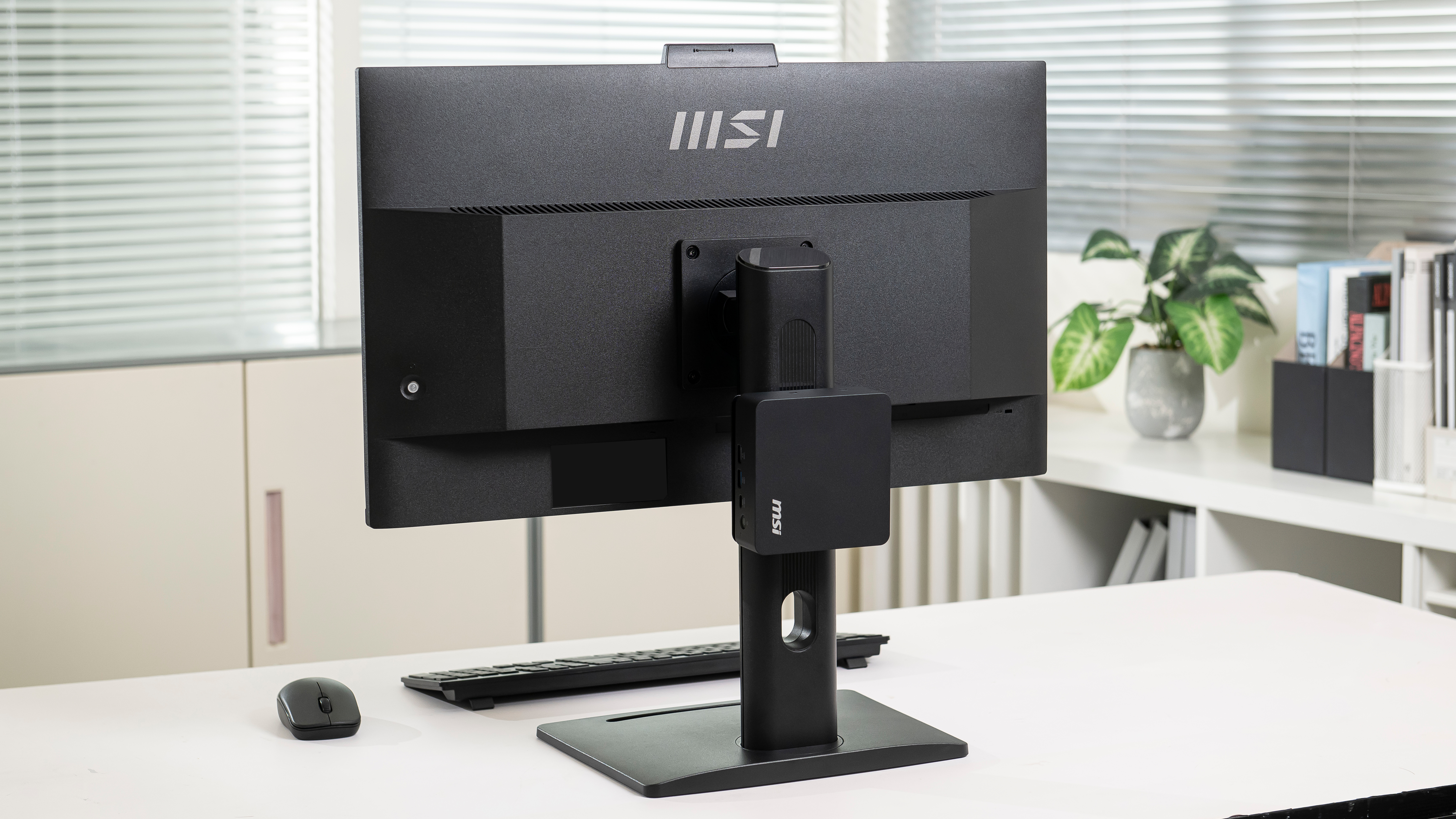 The MSI Cubi NUC AI+ 3MG attached to the back of a monitor.
