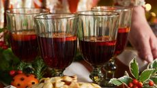 A woman holding a tray of mulled wine