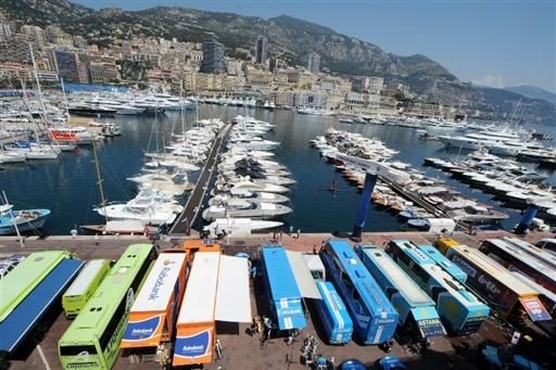 Team buses are parked along the harbor in Monaco.