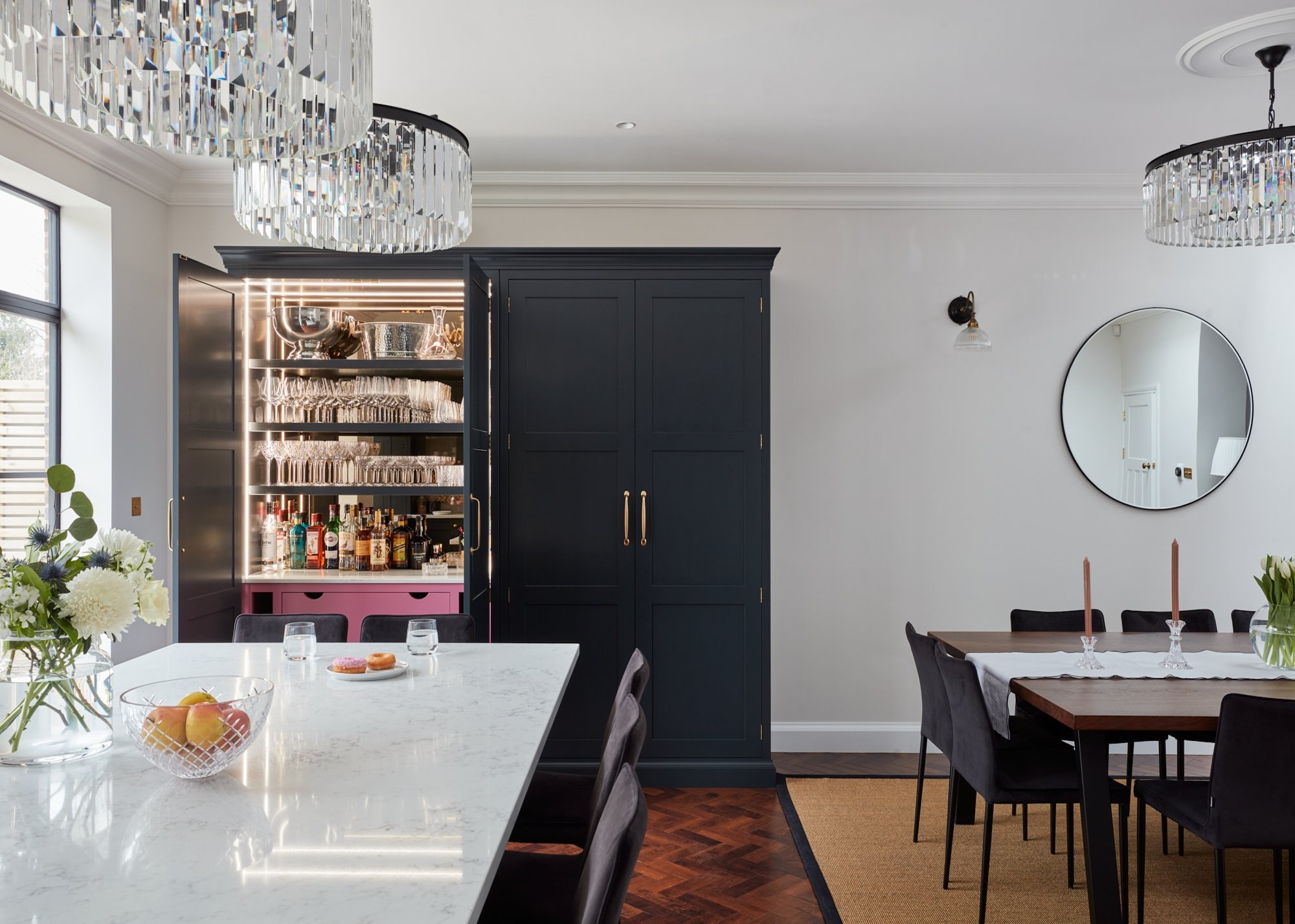 A kitchen with a large home bar and a view of the dining table.