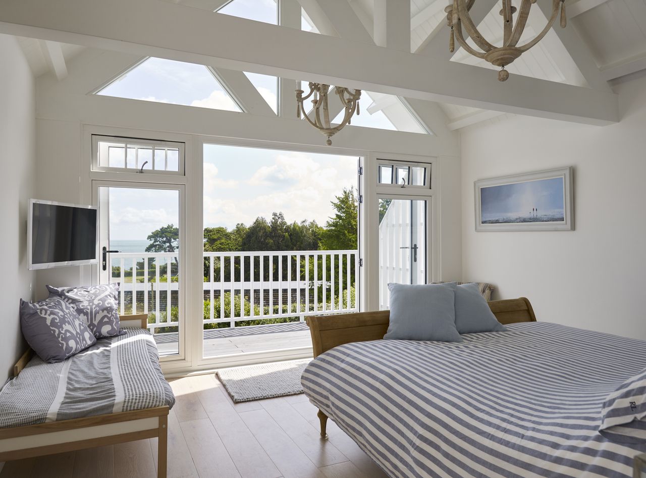 bedroom with balcony and exposed beams