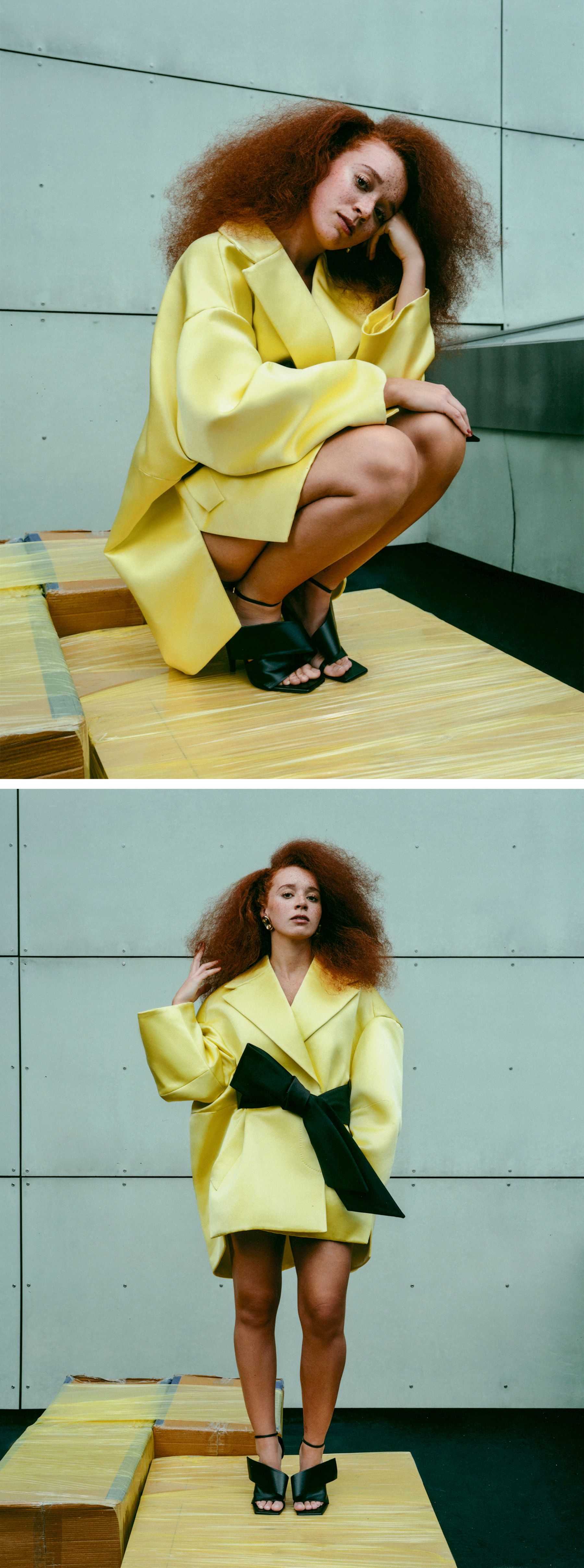 Photos of Erin Kellyman for the Fall Ones to Watch portfolio. She is pictured against an urban backdrop wearing a yellow Givenchy coat dress, shoes, and earrings.