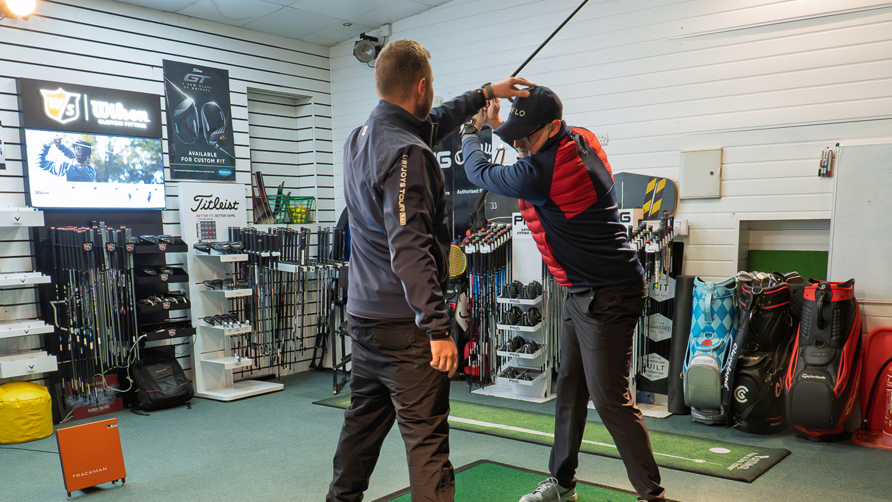 Top 50 Coach Joshua Mayo holding the head of Rob Spedding in a golf lesson to prevent him following the clubhead with his eyes in the backswing