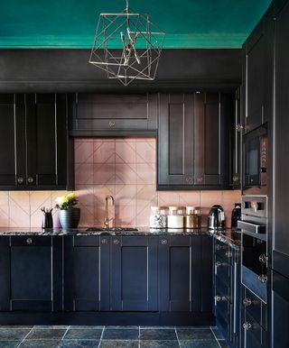Black kitchen with pink tiles