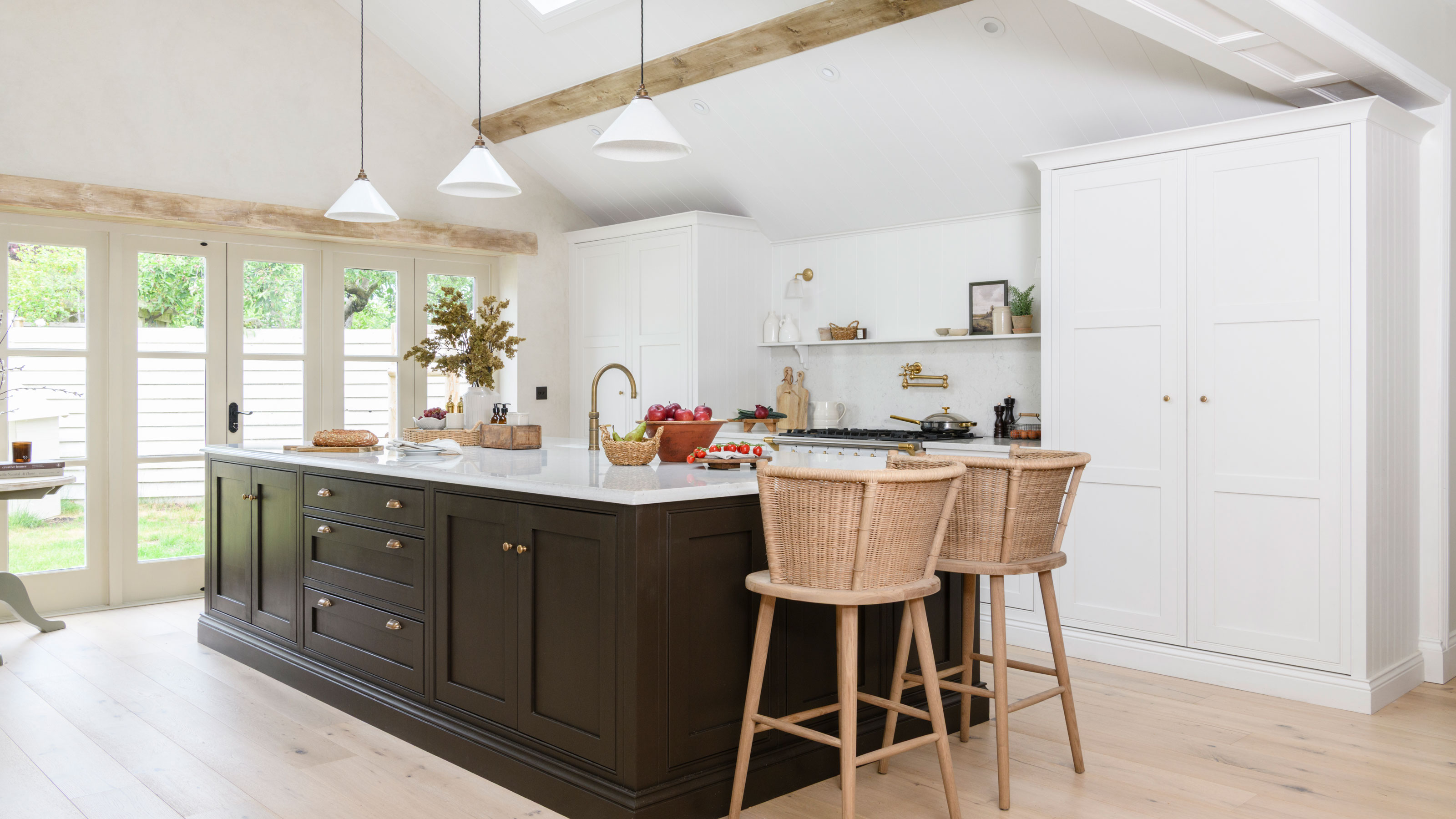 Black and white kitchen with white conical lighting above the kitchen island