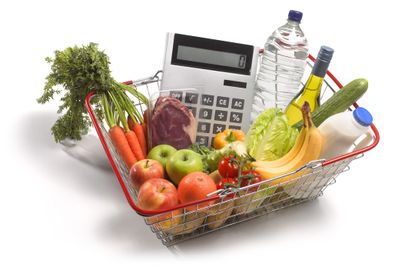 a shopping basket filled with groceries and a calculator
