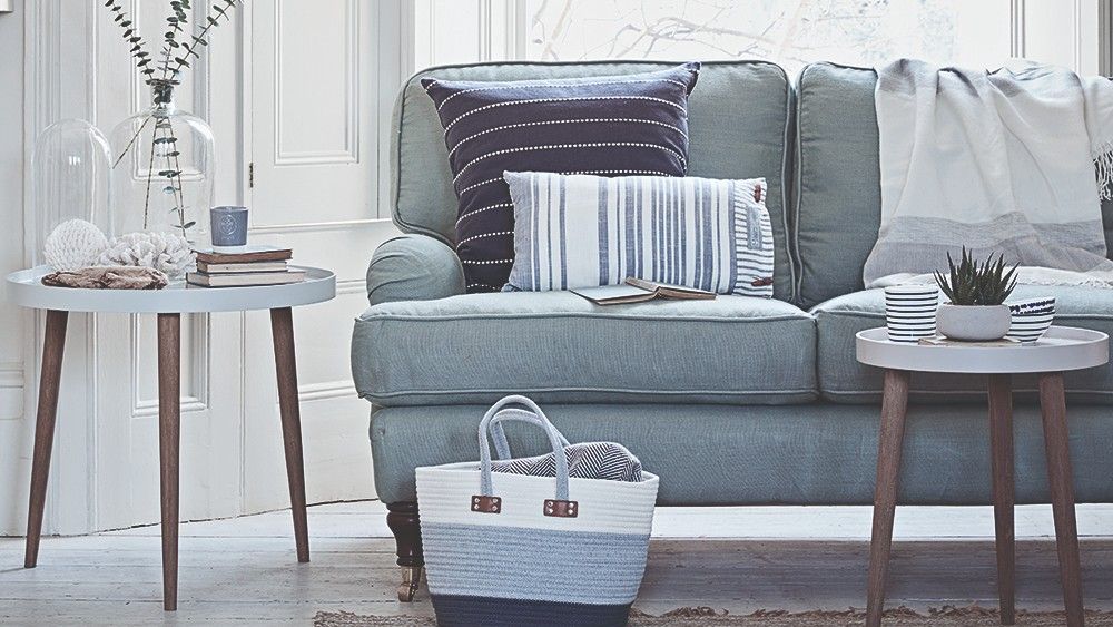 wooden flooring with basket and sofa with cushions