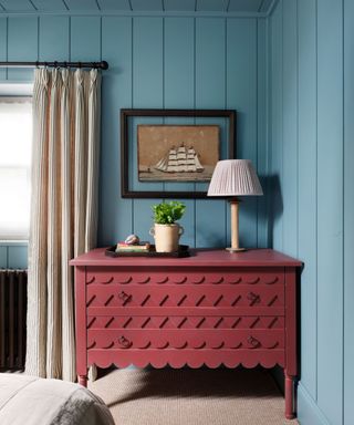 bedroom with blue walls and dark red dresser