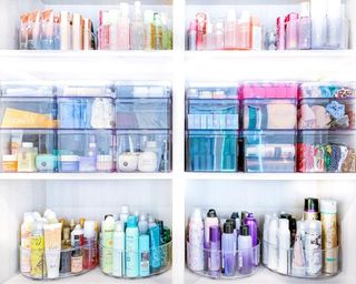 A bathroom cupboard or vanity with products organized into acrylic bins and turntables