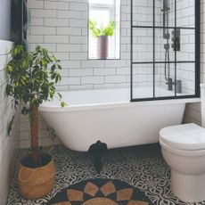 A white-toled bathroom with a bathtub and a patterned tiled floor