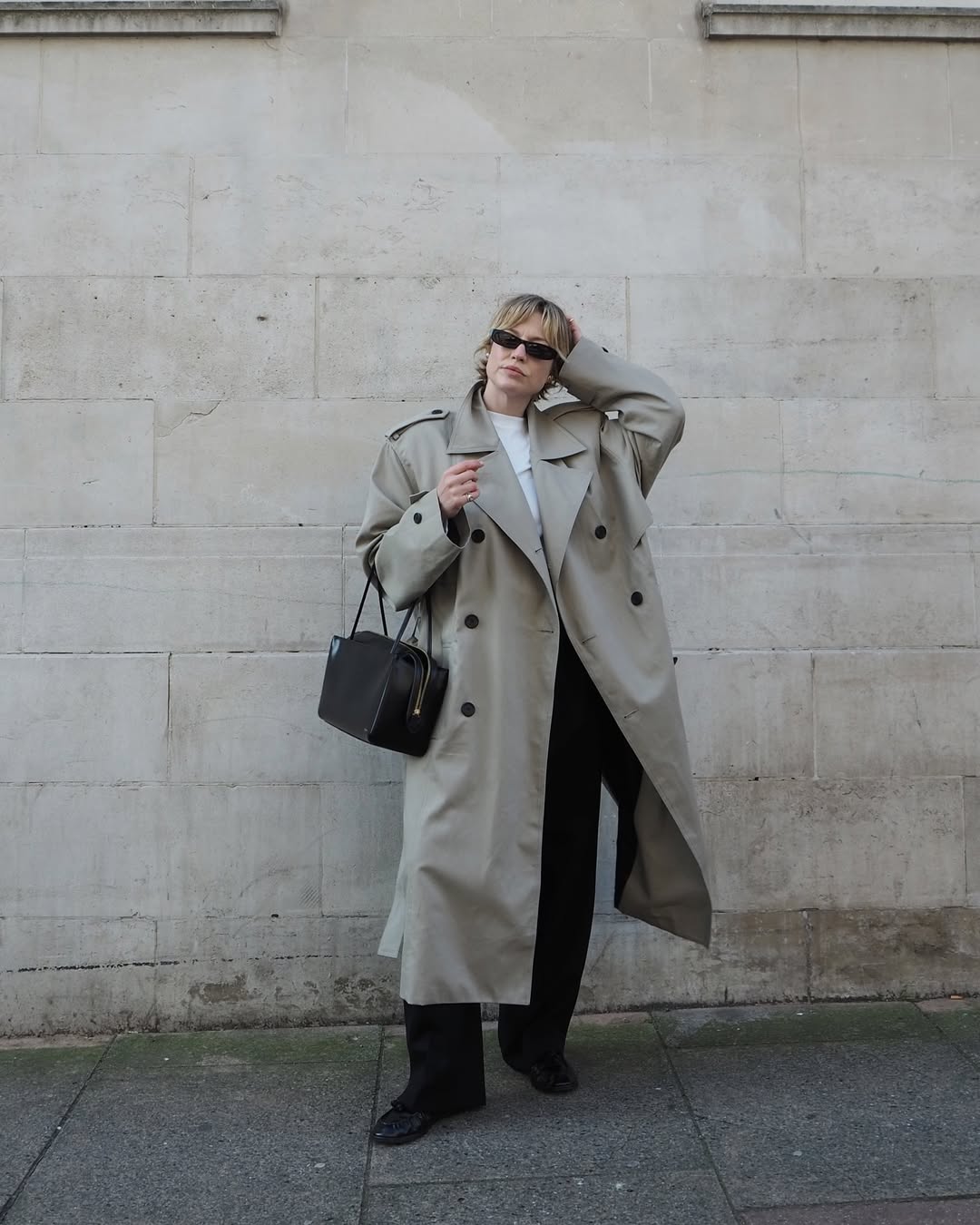@alexisforeman wears trench coat, black jeans, black bag