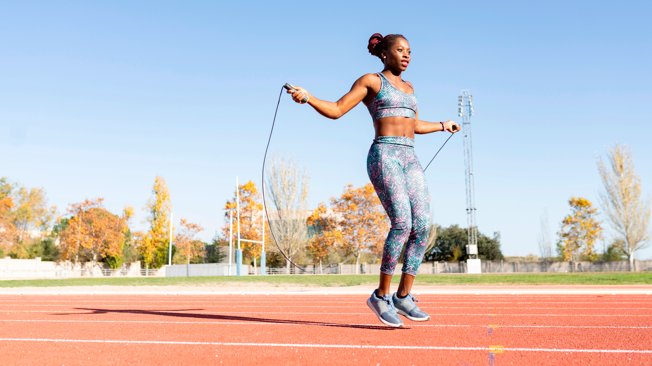 Woman skipping with jump rope on running track