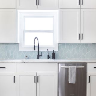 Blue modern edged tiled backsplash in modern kitchen with white gloss finished cabinets