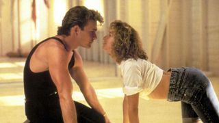 patrick swayze and jennifer grey practicing in a dance studio and leaning in to kiss in the movie dirty dancing