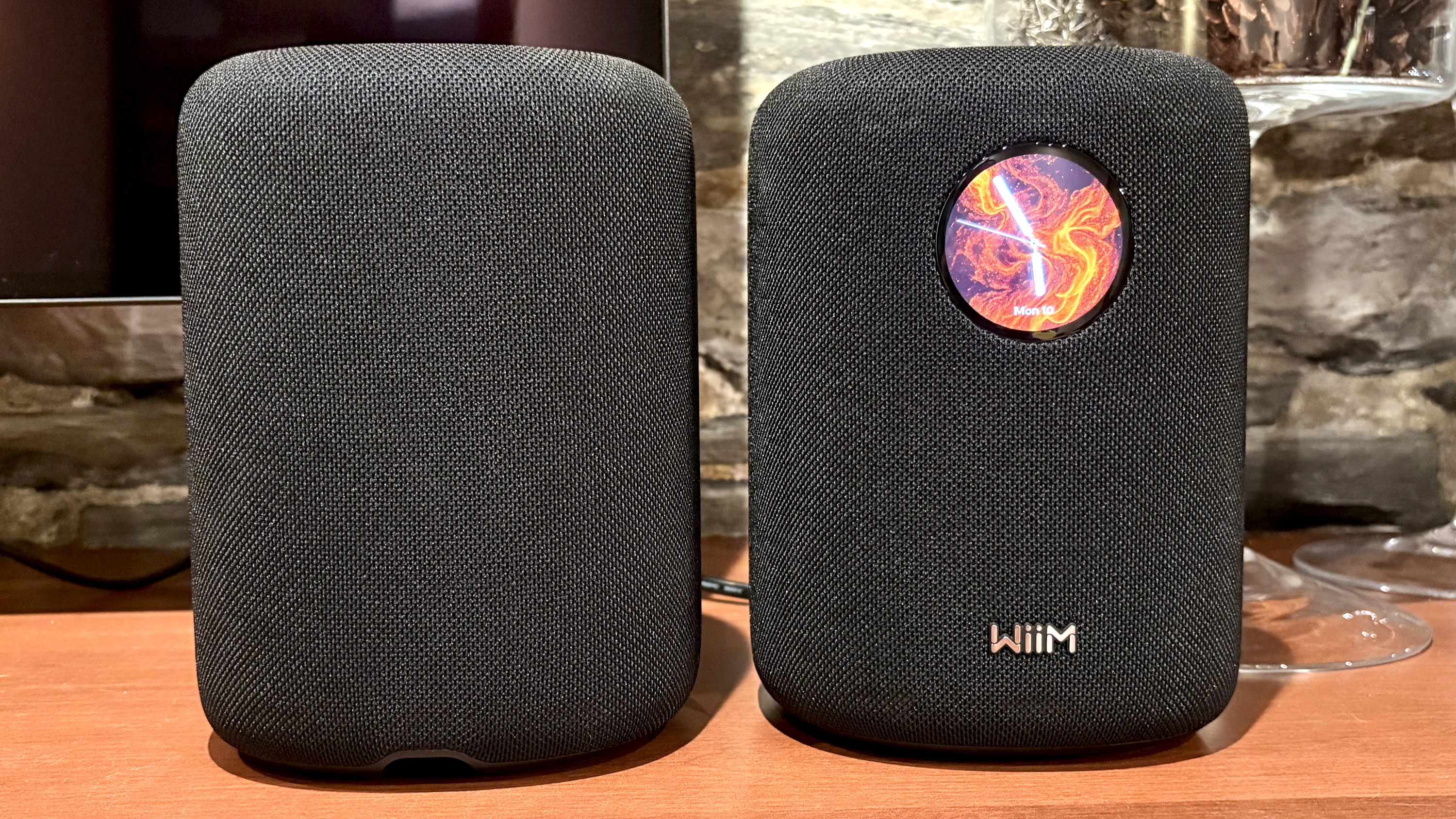 The WiiM Sound, in a home, on a varnished wooden table, showing the illuminated front panel