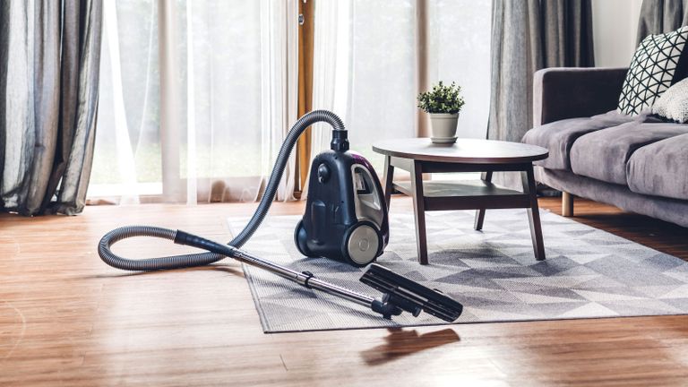 vacuum cleaner in a living space with rug and coffee table