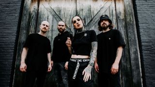 Jinjer posing in front of a barn door