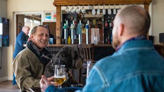 Two men at the pub with their dog