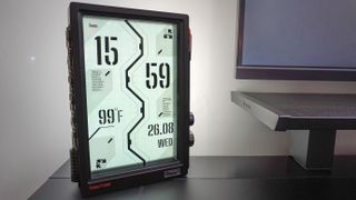 The Divoom Times Frame on the edge of a desk with a black and white clock face on its display