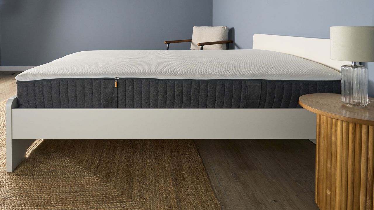 A side on view of the Emma Hybrid Airgrid Mattress on a bed frame in a bedroom