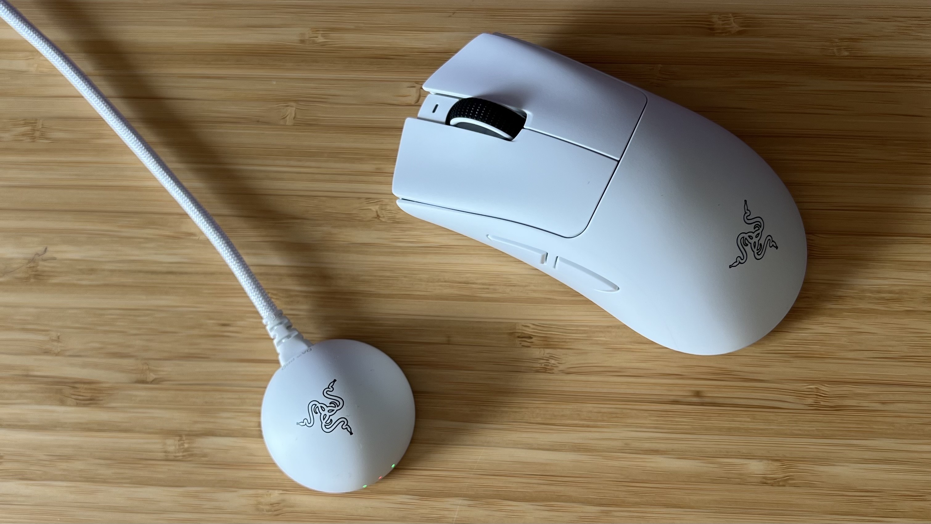 Razer DeathAdder V4 Pro gaming mouse and 8,000Hz polling receiver on a wooden desk